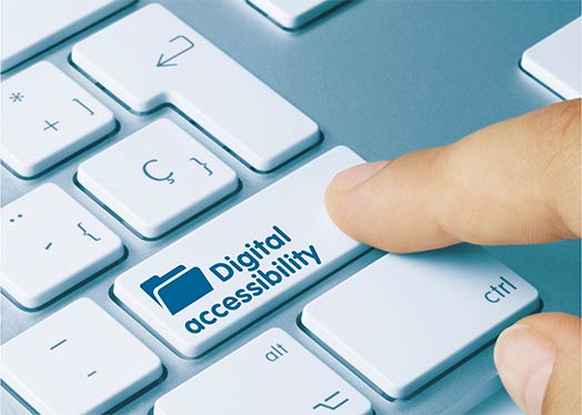 A keyboard with finger on the digital accessibility key